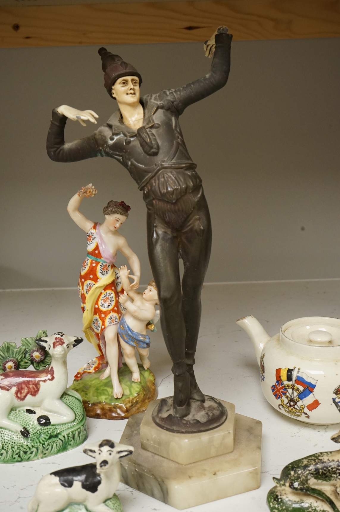 An Art Deco resin and patinated spelter model of a dancer on onyx base, two late 18th century Staffordshire coloured creamware recumbent cows and a spongeware deer, a WWI commemorative teapot with ‘For Right and Freedom’